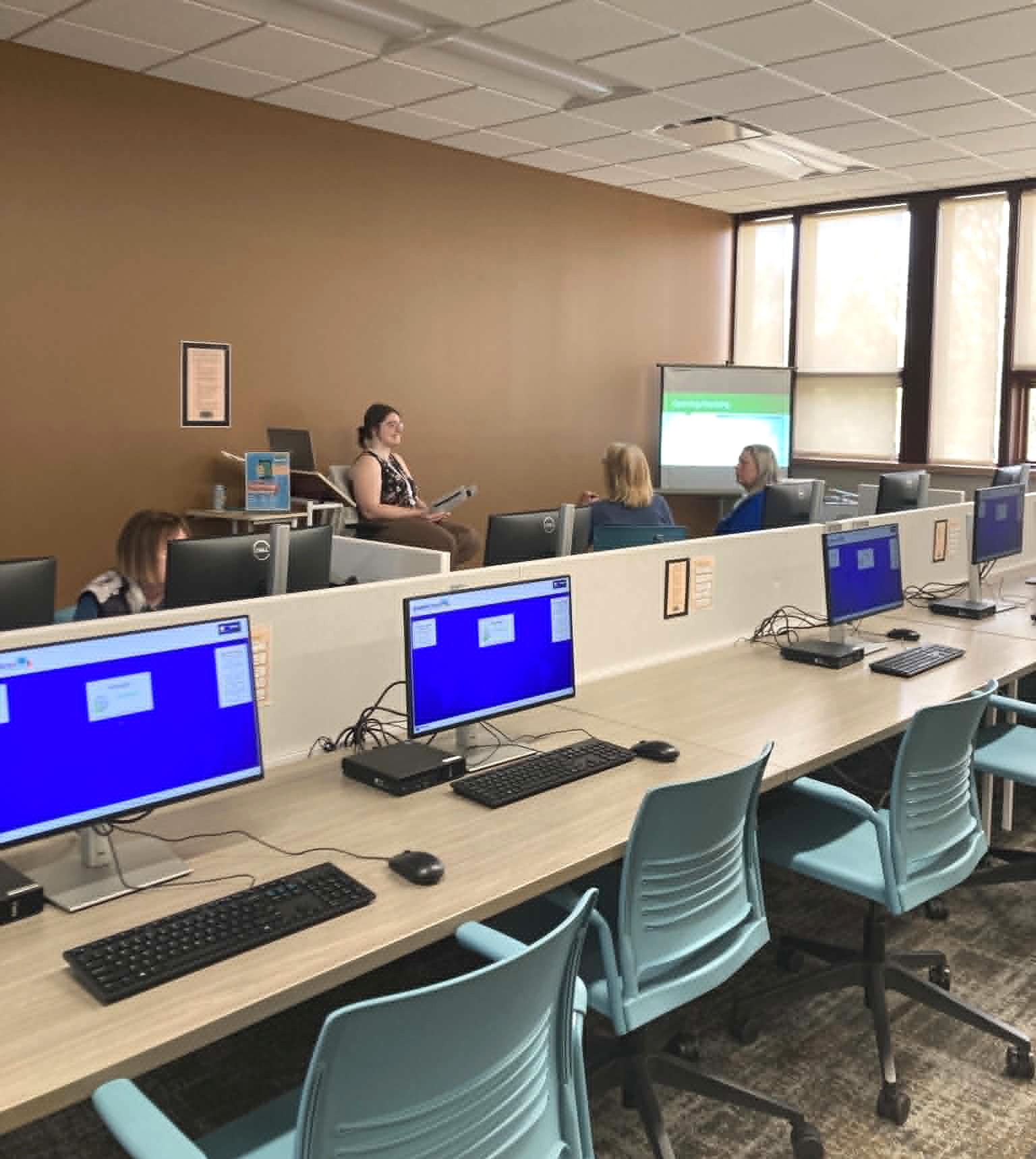 Photo of our computer lab with a librarian leading a class