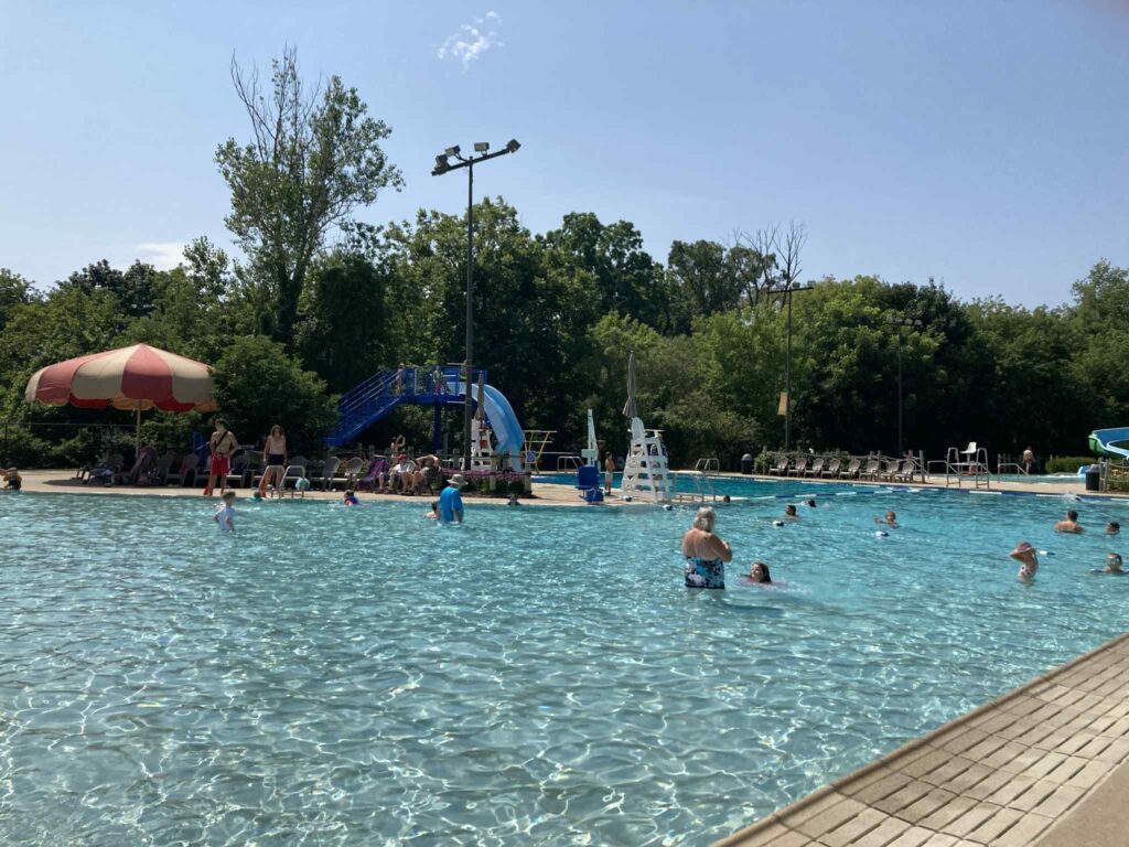 Pirates Hollow Community Waterpark pool image with slide and umbrella